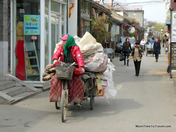 Hutong resident on tricycle transporting materials to be recycled