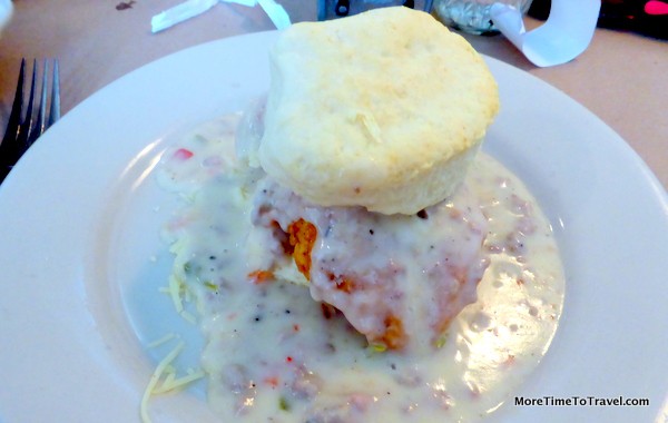 Charleston Nasty biscuit with fried chicken topped with cheddar cheese and sausage gravy