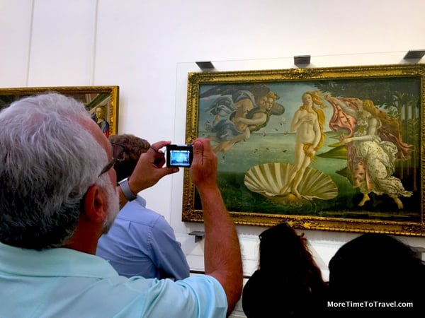 Tourist taking a photo in the Uffizi Gallery in Florence