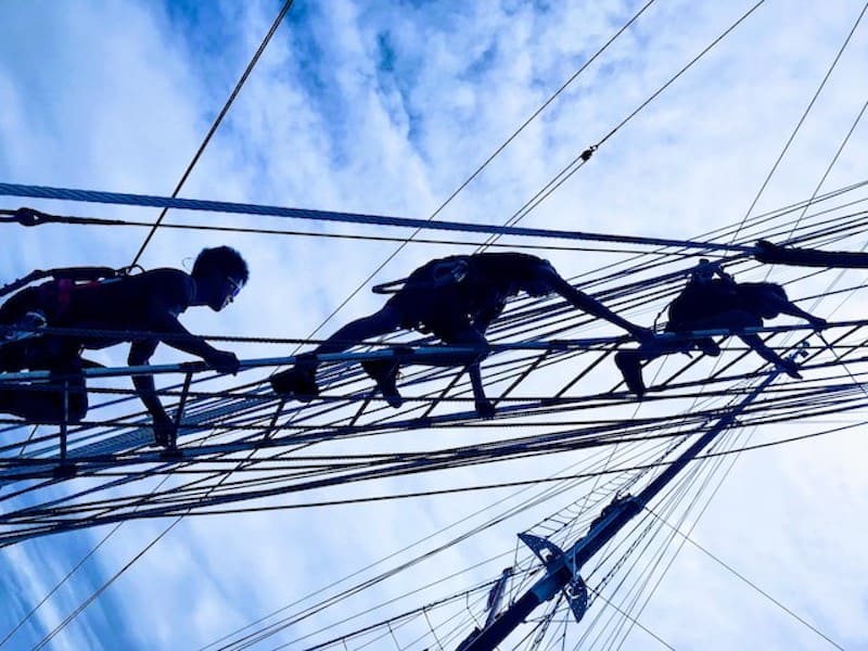 Crew members climbing the ropes