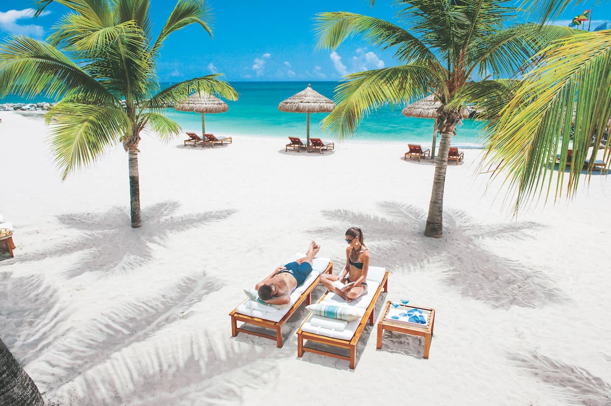 Couple reading on the beach at Sandals South Coast