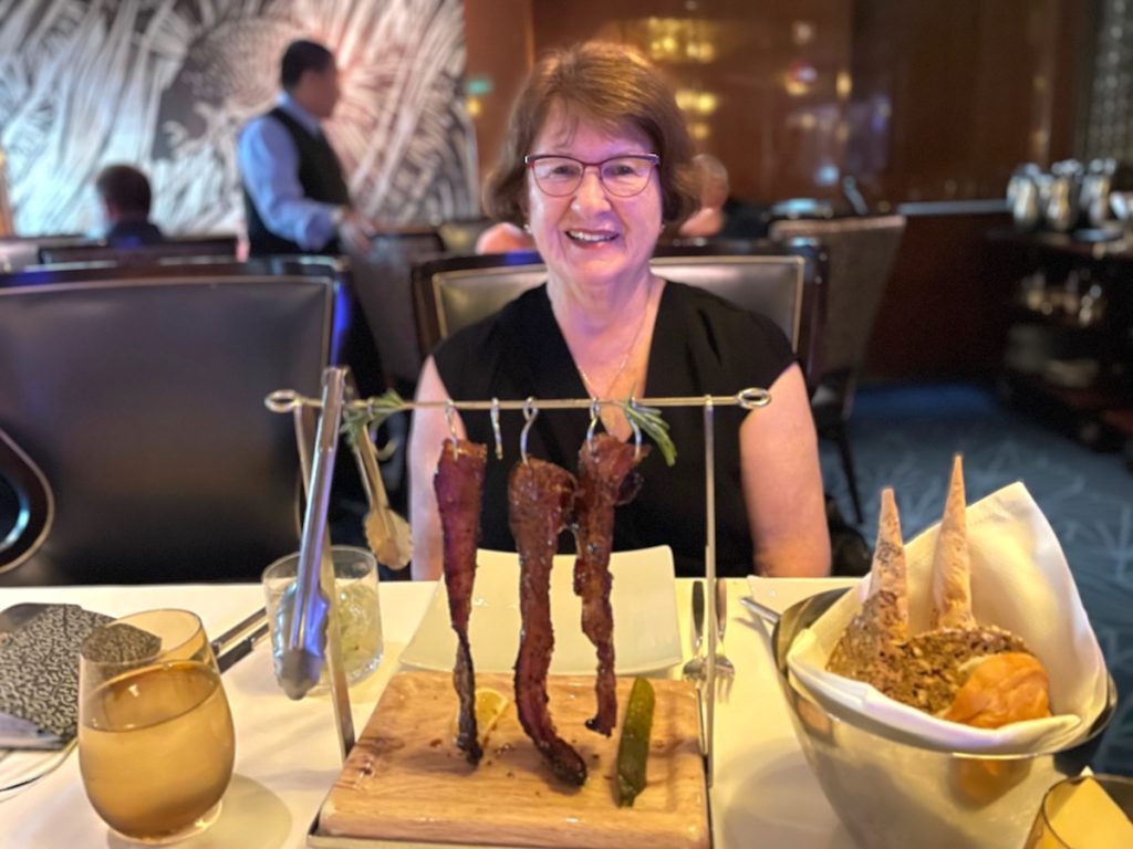 Author Sandra Nowlan enjoying Clothesline Candied Bacon at Pinnacle Grill (credit: John and Sandra Nowlan)