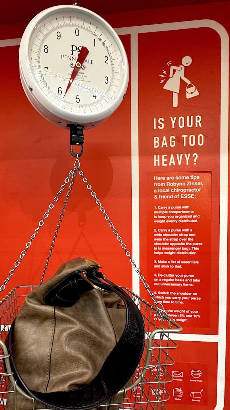 A visitor weighs her bag along with seeing tips about heavy bag safety (credit: Jackie Sheckler Finch)