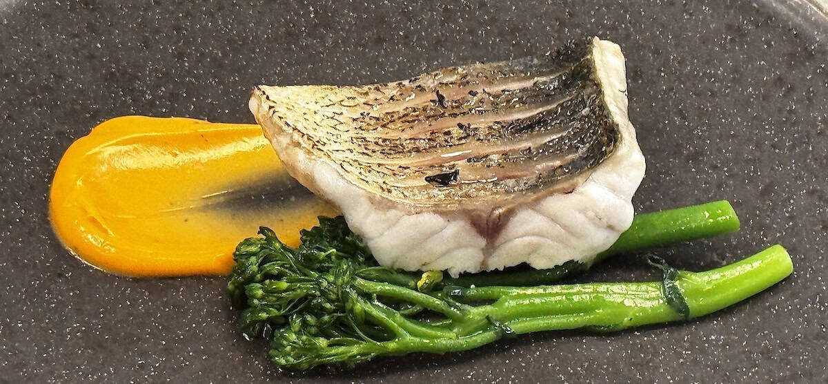 Grilled sea bass with Manteca Colorá hollandaise and charred broccoli with lime is featured at La Carboná (credit: Jackie Sheckler Finch)