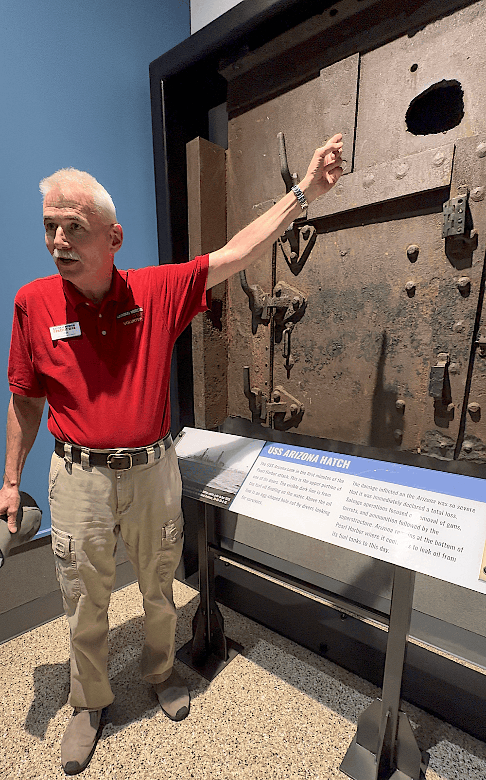 Volunteer museum guide Dee points to the hatch of the USS Arizona, which sank in the first minutes of the Pearl Harbor attack and remains at the bottom of Pearl Harbor (credit: Jackie Sheckler Finch)
